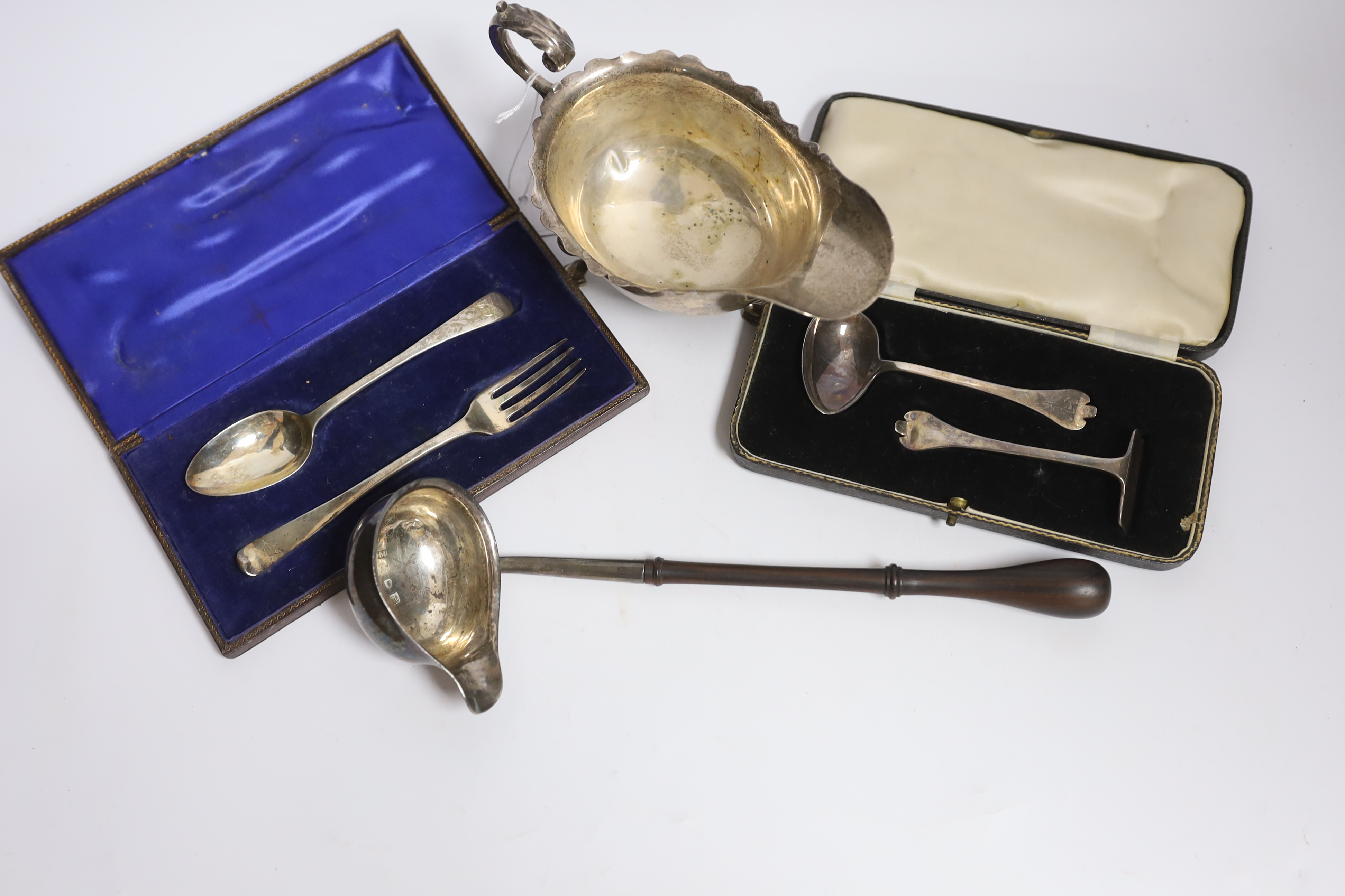 A small group of silver items to include a George V sauceboat, London, 1934, a George III toddy ladle, London, 1766 and later cased christening cutlery, etc.